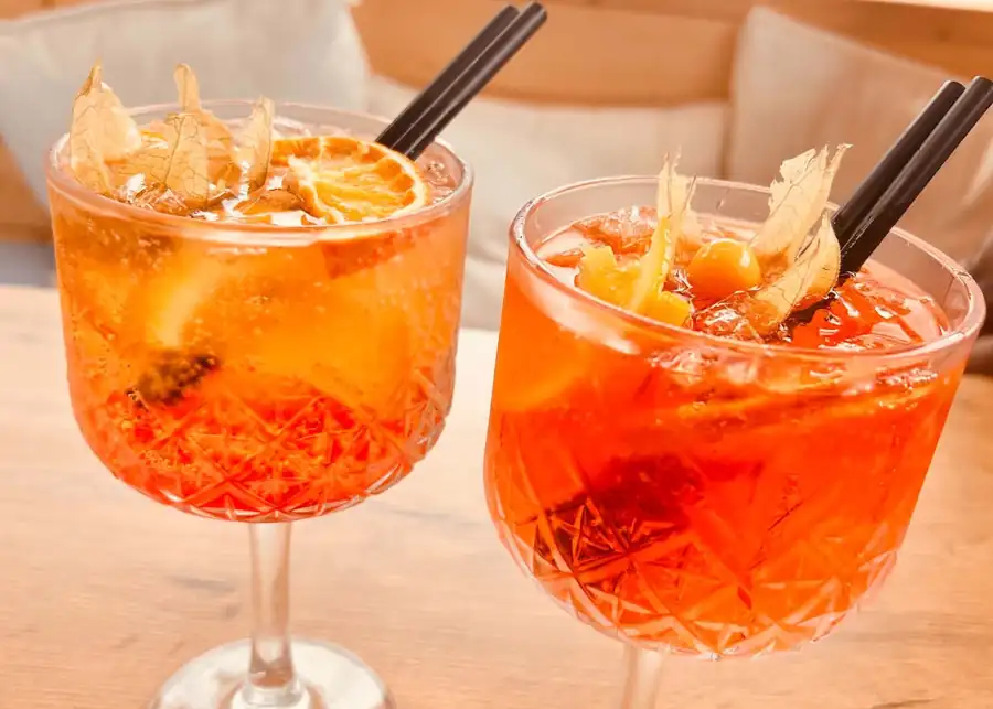 Dwa pomarańczowe drinki na drewnianym stole